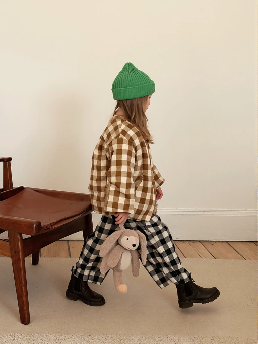 模特穿着收口牛仔裤的黑色踝靴,地毯背景,侧身45度视角展示。