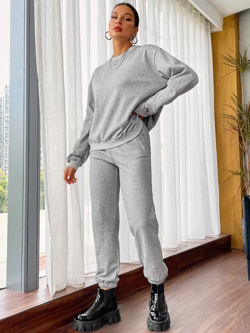 Modelo negro usando sudador gris y pantalón deportivo en interior moderno