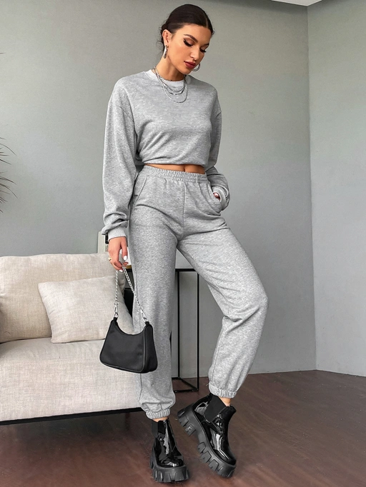 Foto profesional AI Pasang Pakaian pada Model untuk Set Sweat dengan Model Studio yang menampilkan Model Studio mengenakan Set Baju Olahraga di lokasi studio interior minimalis, gaya rileks dan profesional.